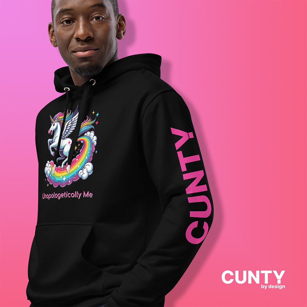 Man Wearing the Black premium eco-friendly hoodie featuring a vibrant, winged unicorn with a rainbow tail and the words Unapologetically Me below. Bold pink CUNTY branding on the sleeve, set against a pink gradient background. A statement piece for confidence, self-expression, and empowerment. Cunty by design
