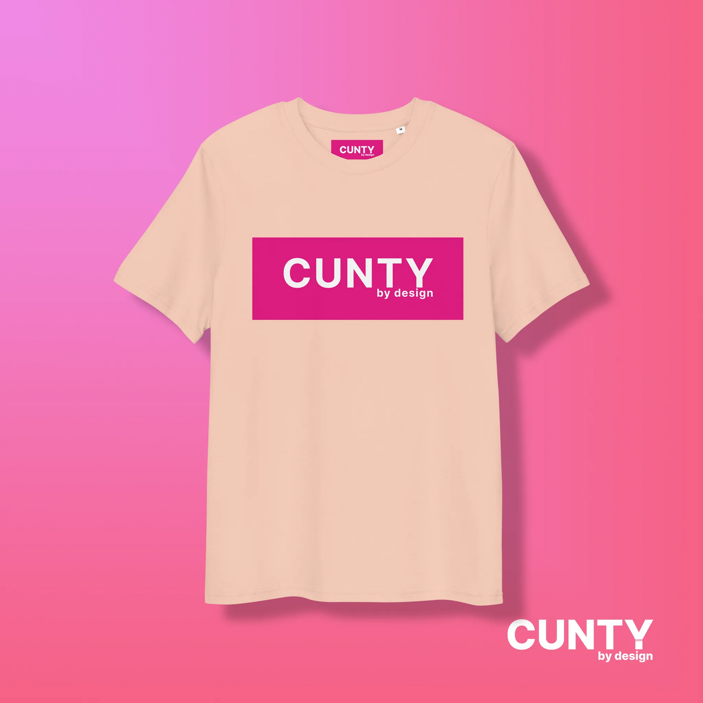 Fraiche Peche with Fuchsia Design: A peach-colored unisex t-shirt featuring the "Cunty by Design" logo in a bold fuchsia rectangle, on a pink gradient background.