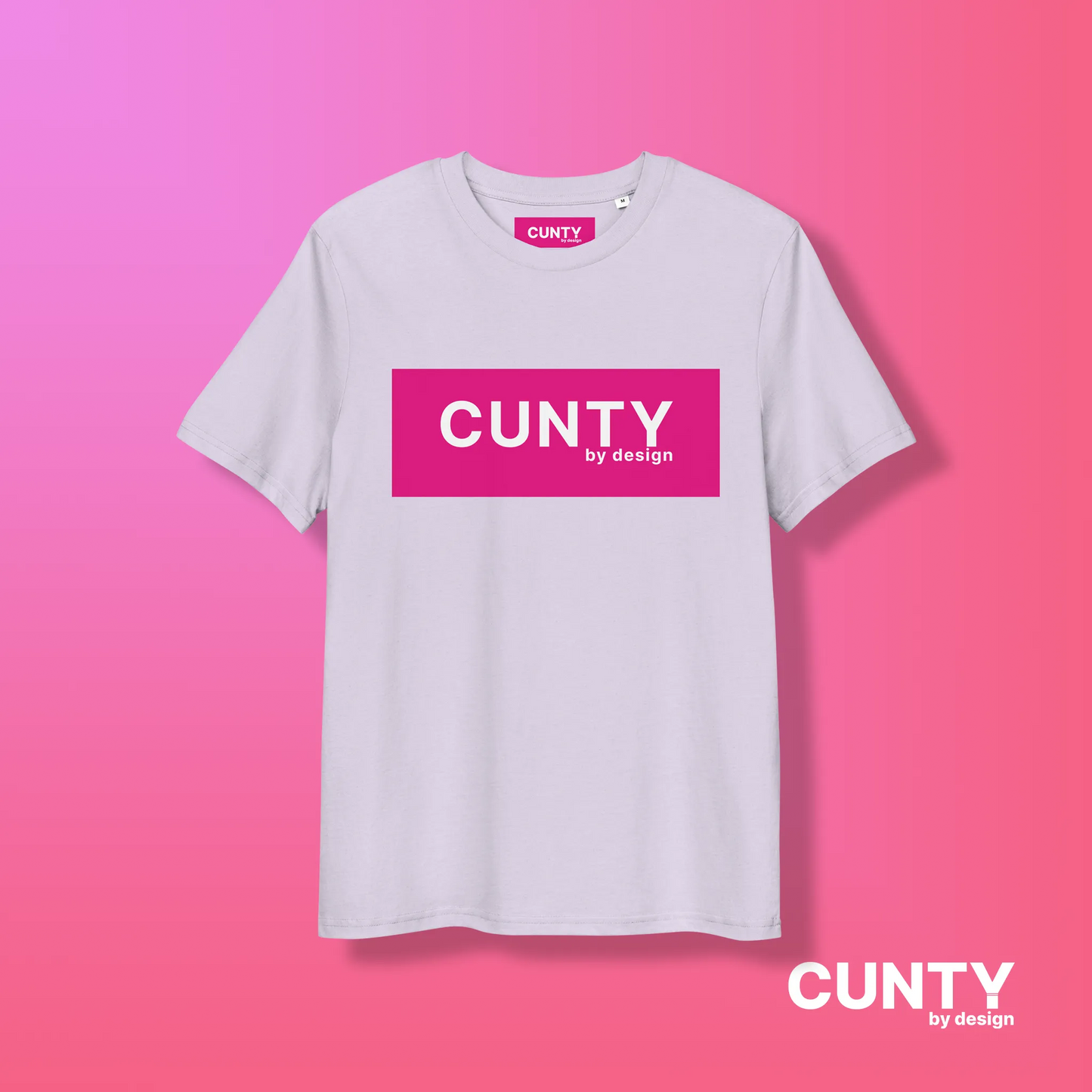 Lavender with Fuchsia Design: A soft lavender unisex t-shirt featuring the bold "Cunty by Design" logo in a vibrant fuchsia rectangle, displayed on a pink gradient background.
