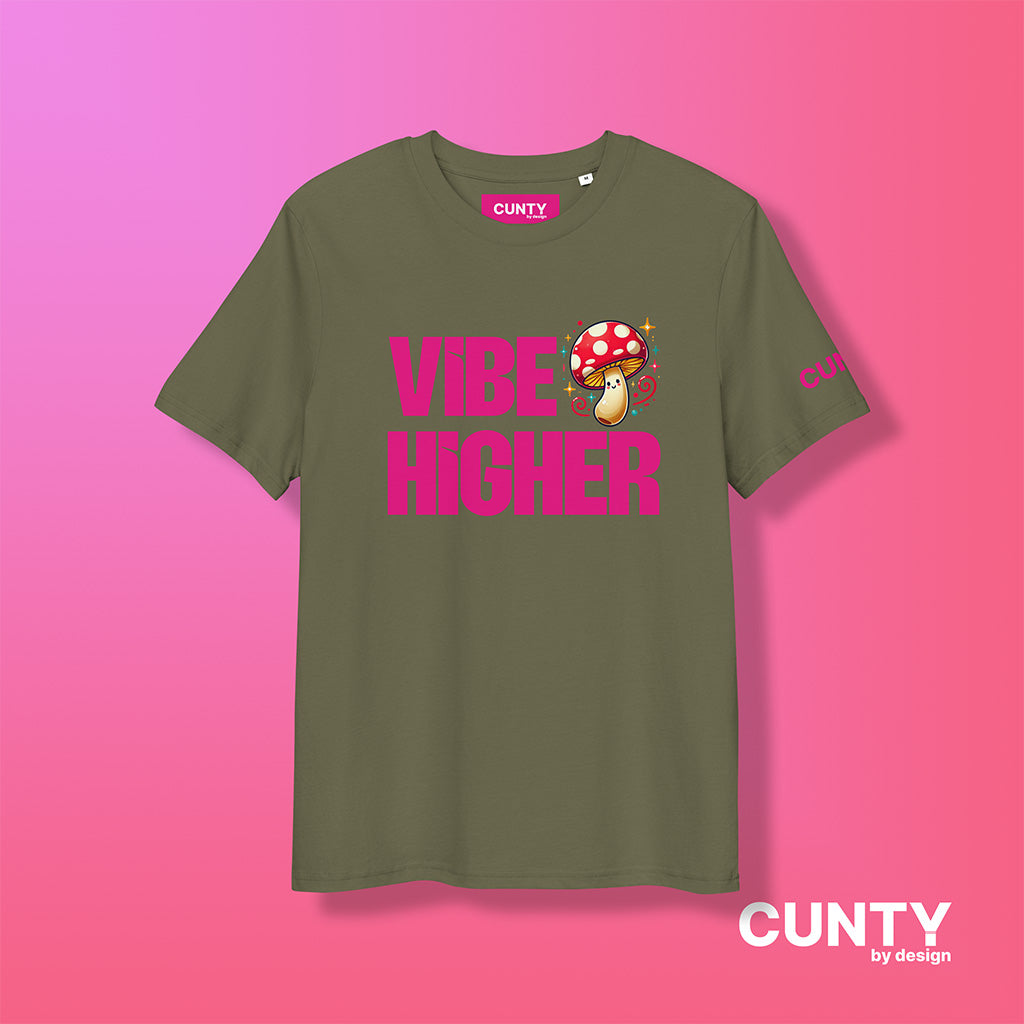 khaki organic cotton t-shirt featuring the bold text "Vibe Higher" in vibrant pink, paired with a colorful magic mushroom graphic. The shirt has a unisex design with a Cunty by Design logo on the sleeve, and inside neck label displayed against a fuchsia background.