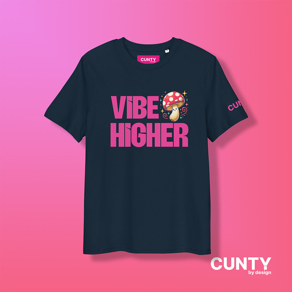 navy organic cotton t-shirt featuring the bold text "Vibe Higher" in vibrant pink, paired with a colorful magic mushroom graphic. The shirt has a unisex design with a Cunty by Design logo on the sleeve, and inside neck label displayed against a fuchsia background.