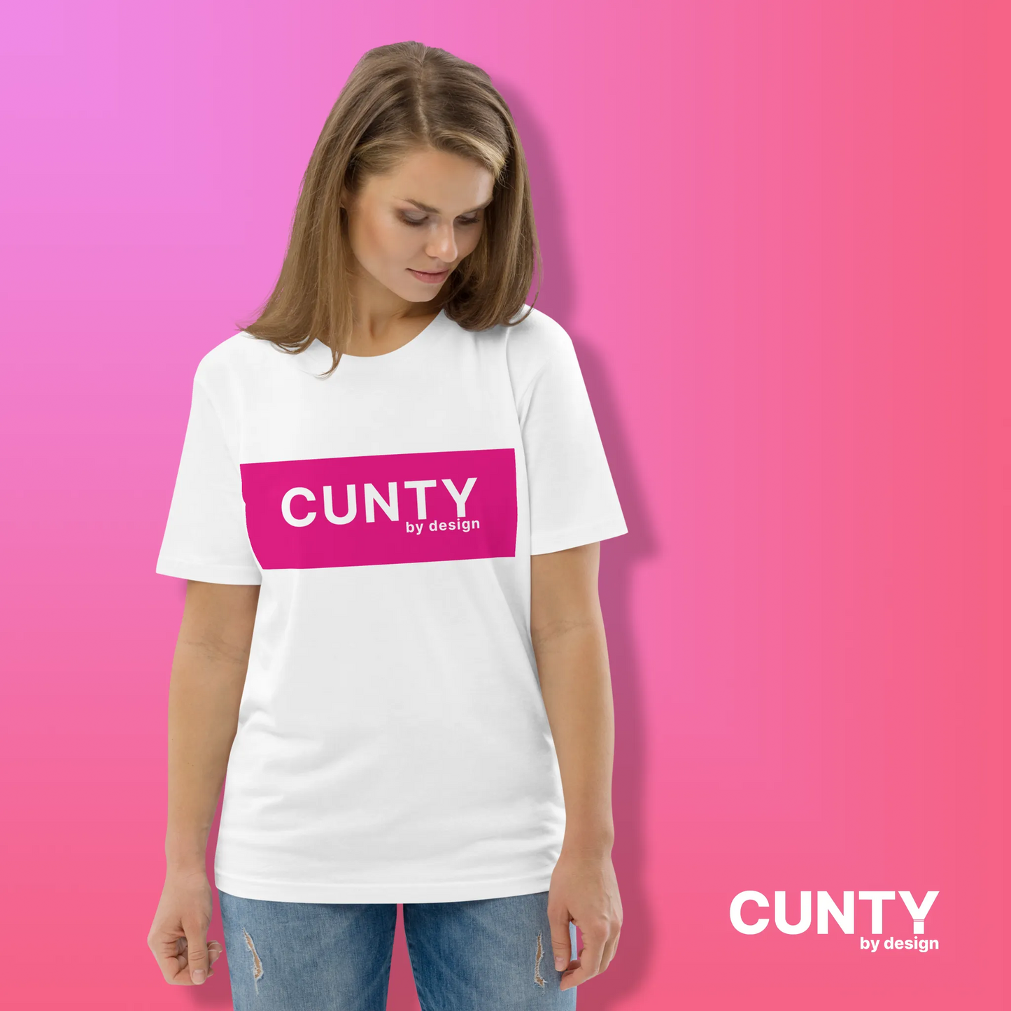 Woman in White with Fuchsia Design: A woman wearing a white unisex t-shirt with the bold "Cunty by Design" logo in a fuchsia rectangle, styled against a pink gradient background.