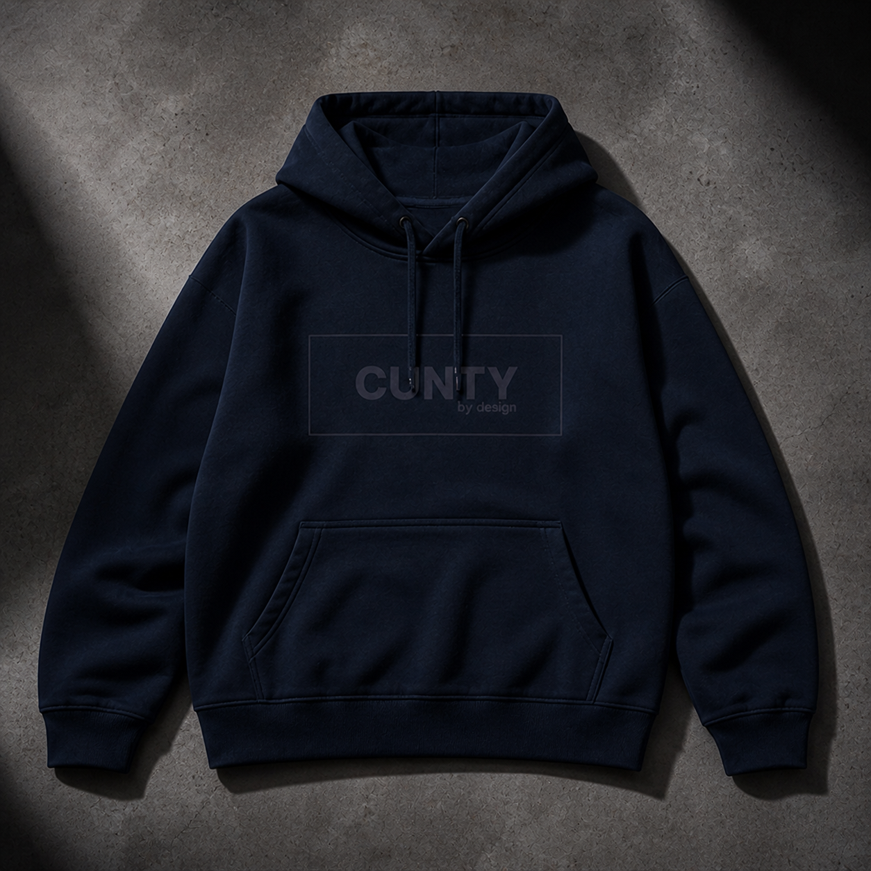 French Navy Blue hoodie with 'CUNTY' logo text on a gray concrete surface